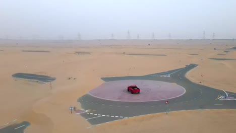 Camión-Rojo-Haciendo-Donuts-En-Una-Carretera-Vacía-En-El-Desierto,-Drones-En-órbita