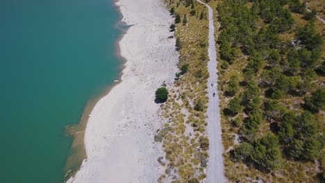 Top-down-shot-of-to-scooter-drivers-next-to-a-sea---water