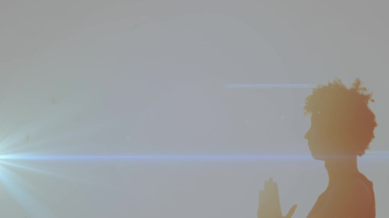 Animation of light trails over african american man doing yoga at beach