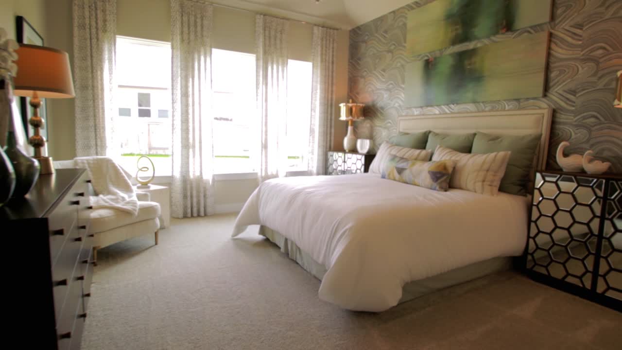 toma de gran angular de la grúa de un dormitorio principal con una cama tamaño king, ventanas grandes y una decoración muy agradable