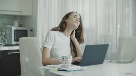 Mujer-Cansada-Trabajando-En-Una-Computadora-Portátil-En-Casa.-Mujer-Estresada-Tocando-El-Cuello