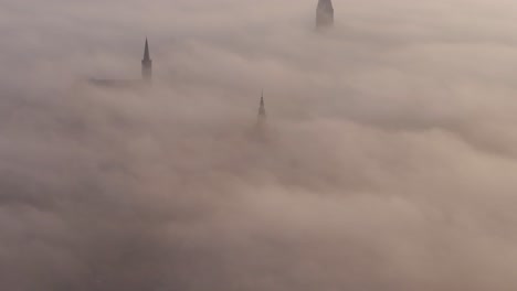 bolsward friesland towers sticking out of thick layer of fog, aerial