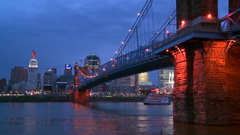 Un-Barco-Fluvial-Viaja-De-Noche-Con-El-Fondo-Del-Horizonte-De-Cincinnati-Ohio