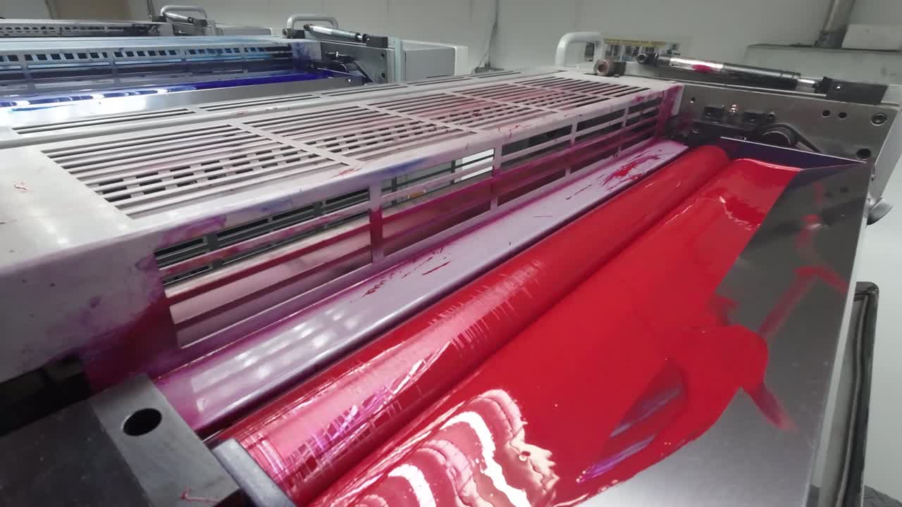 Close up of a printing press roller covered in vibrant red ink