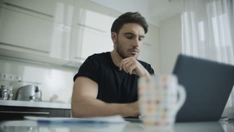 serious man working on laptop computer at home. thoughtful business man