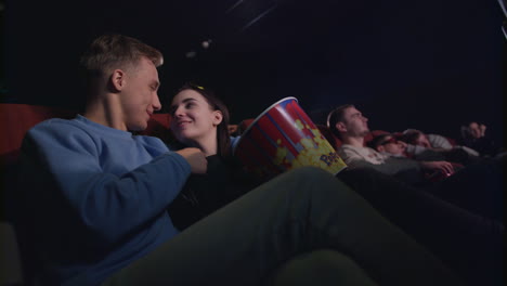 love couple kissing in cinema. romantic couple embracing in movie theatre