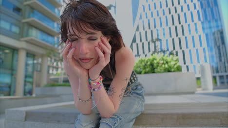 outdoor fashion portrait of young alternative style woman with tattoos and piercing sitting outside modern buildings shot in real time 2