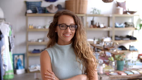 Female-assistant-in-boutique--walks-into-focus,-crosses-arms