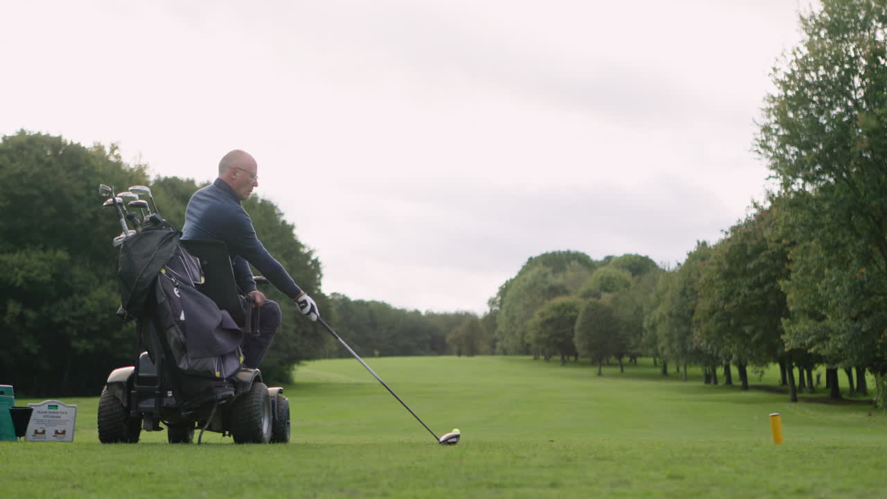 A golfer playing golf from a golf cart
