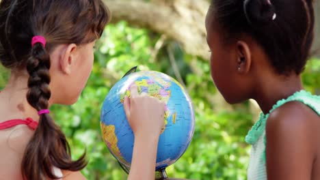 schoolkids looking at globe in campus at school