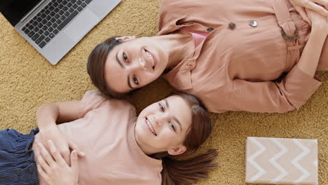 mother and daughter lying on carpet