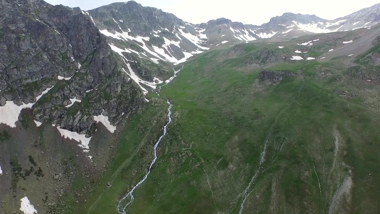 Vista aerea di un ruscello di montagna che scorre attraverso una valle verde