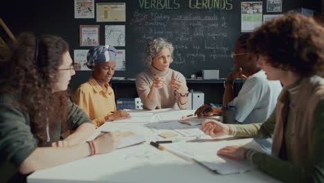 students and teacher discussing ideas and taking notes on english lesson