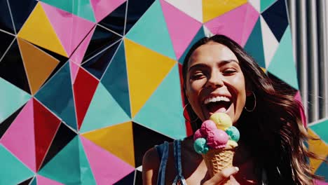 woman enjoying an ice cream cone in front of a colorful wall