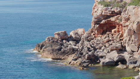 a rock formation standing against gentle waves of the blue sea, showcasing the timeless beauty of a mallorcan summer