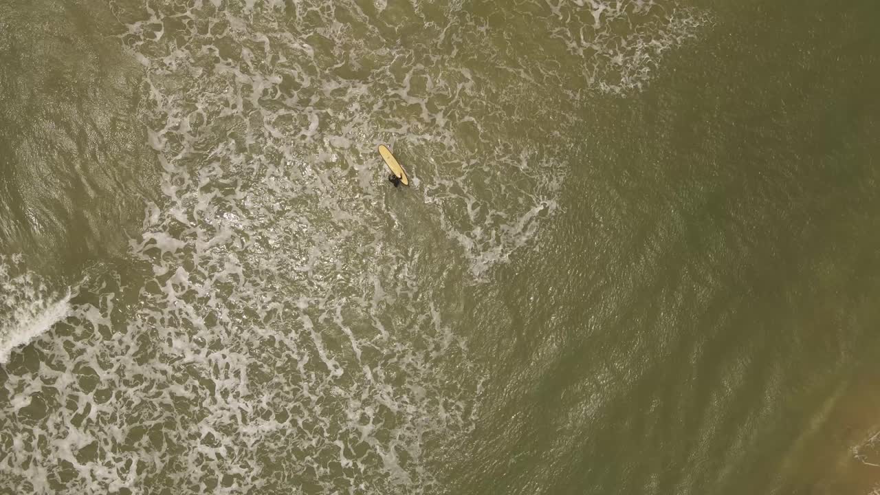 우루과이 라 페드레라 해변에서 대서양에 들어가는 서퍼 남자