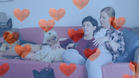 animación de iconos de corazón rojo sobre pareja de mujeres con perros mascotas.