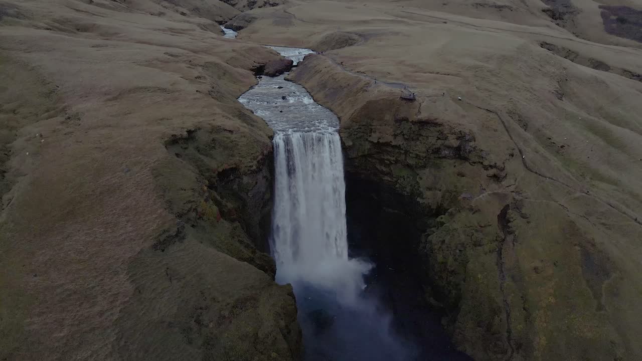 un dron se eleva y retrocede en una toma de establecimiento de la cascada skógafoss en islandia