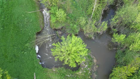 Luftaufnahme-Eines-Fließenden-Baches,-Der-Seine-Ufer-Erodiert-Und-Schließlich-Seinen-Lauf-ändert