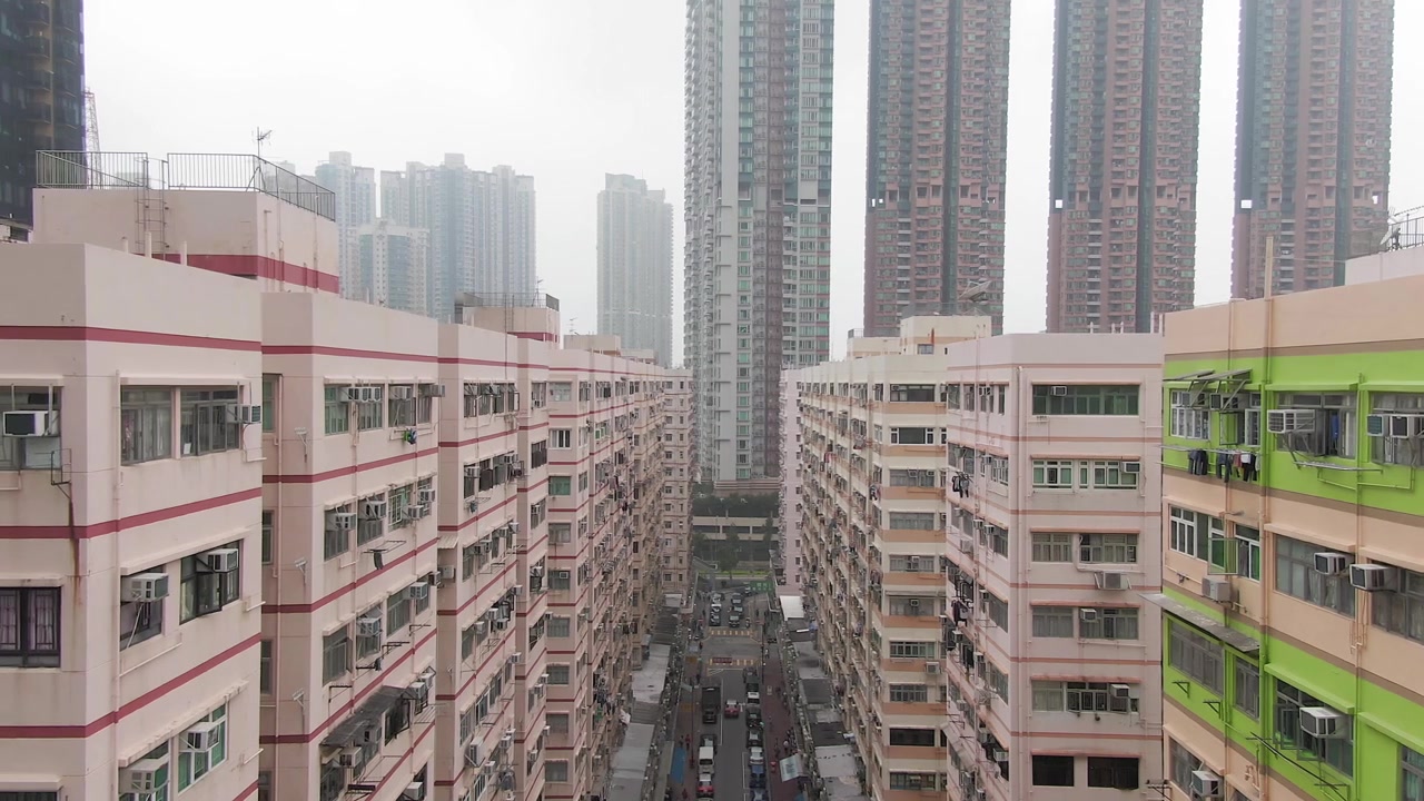 香港旧居民楼与远处地平线上的现代摩天大楼的航拍推拉镜头