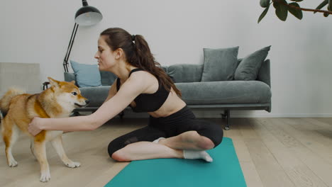 una niña se toma un descanso de su sesión de yoga para jugar con su lindo perro 1