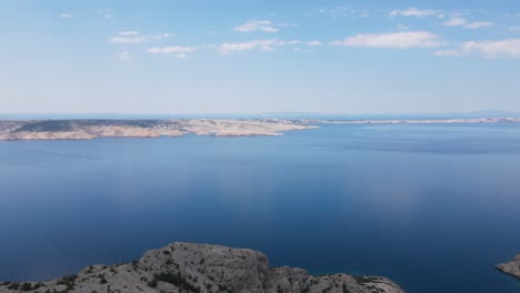 an aerial footage over beautiful beach, green and blue waters of adriatic, stunning barren landscape on island pag, croatia in summer