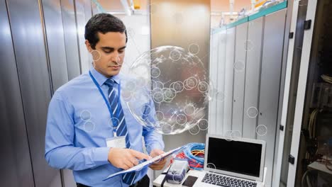 Animation-of-globe-with-icons-over-biracial-male-worker-inspecting-server-room
