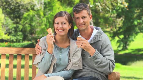 Pareja-Joven,-Comida,-Helado,-Mientras,-Sentado,-En,-Un,-Banco