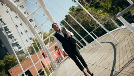 businesswoman walking across a city bridge