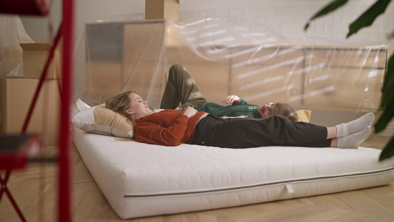 pareja relajándose en un colchón nuevo durante una mudanza