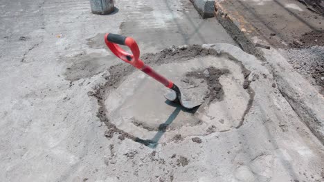 construction site mixing cement with shovel in circular pile outdoors