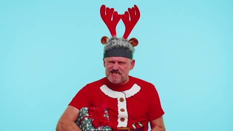 Upset-angry-man-in-Christmas-deer-antlers-raising-hands-in-indignant-expression,-quarreling-conflict