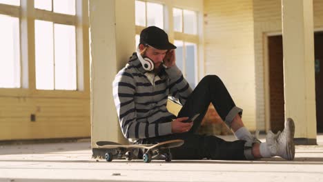 young man listening to music in empty warehouse