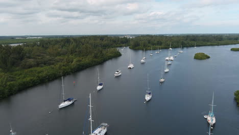 moored luxury yachts and sailboats in a row at vero beach marina during cloudy and sunny day