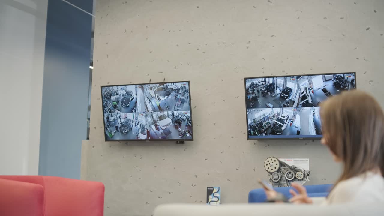 cliente esperando coche en el servicio de coche. cliente viendo el proceso de servicio de coche por transmisión de televisión