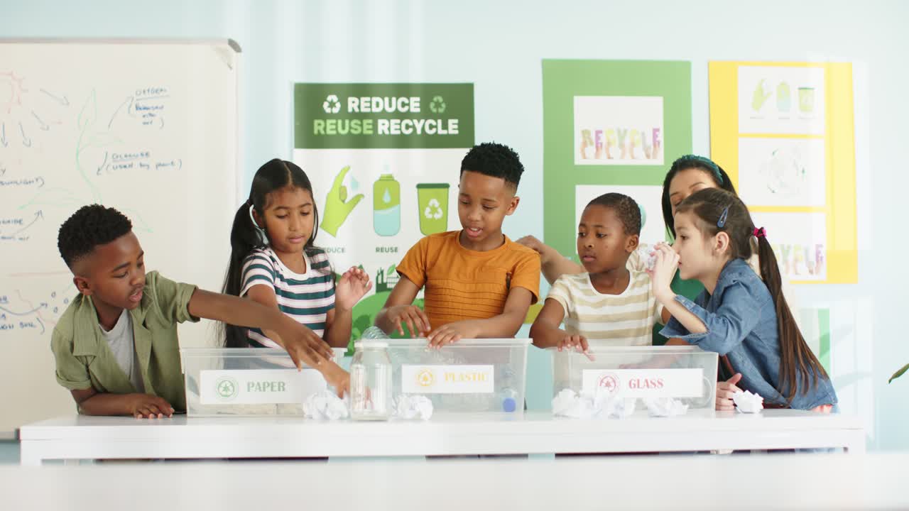 Diverse youths and teacher sorting into PAPER PLASTIC GLASS after boy passing bottle for recycling