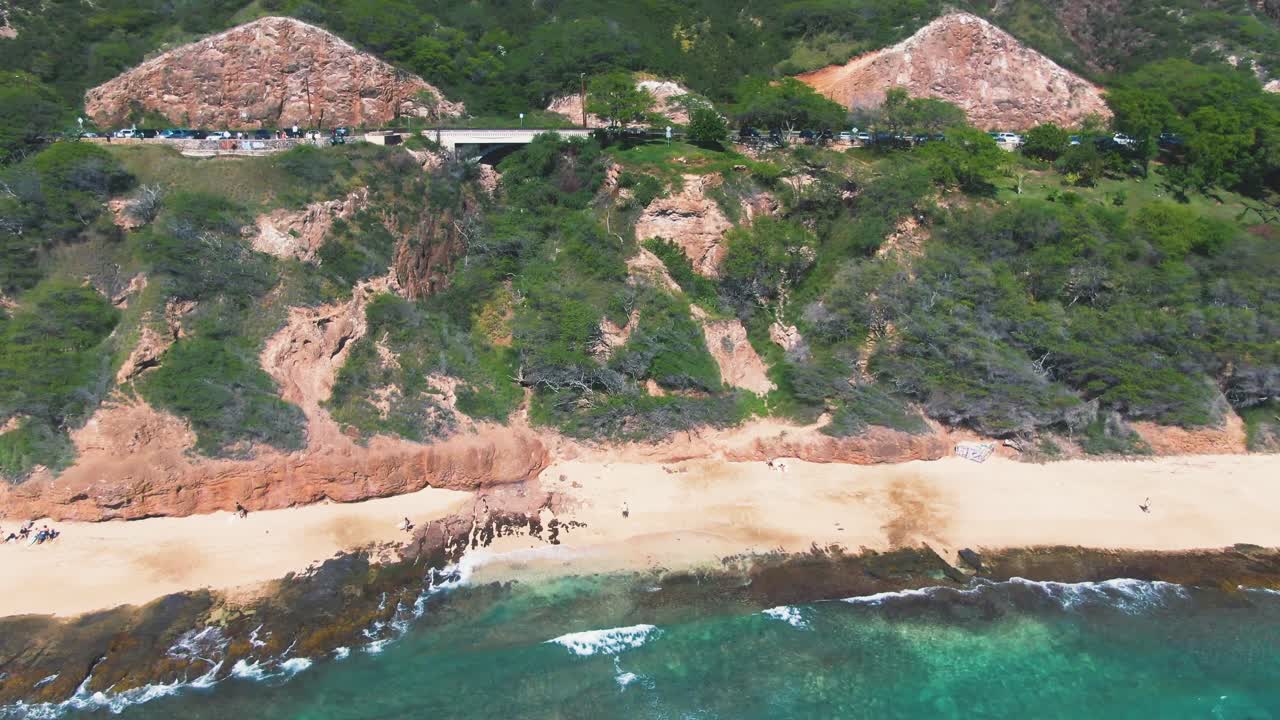 Flying towards the Golden sand beach and steep coast cliffs of Diamond Head Ohau
