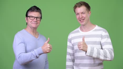 senior handsome man and young handsome man giving thumbs up together
