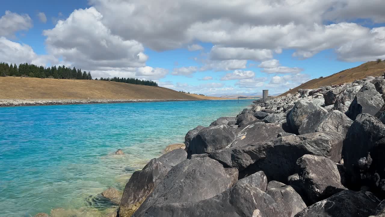 Rocky shore of man-made hydro canal on New Zealand's south island
