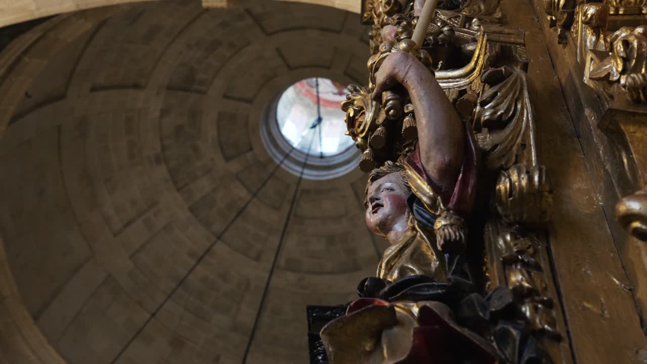 Close up ornate angel sculpture beneath stone dome inside historic church