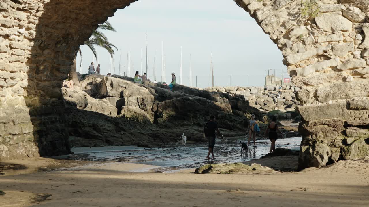 Romanesque Stone Bridge At Praia de Santa Marta Beach In Estoril, Cascais, Portugal. Pan Up Shot
