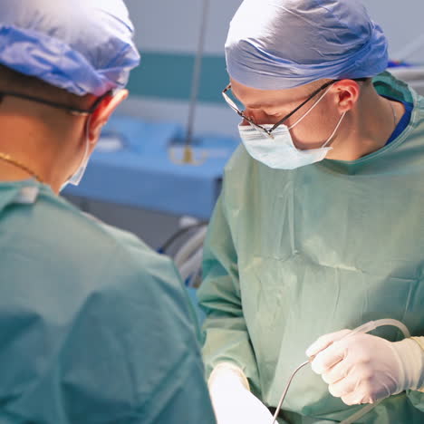 team of professional surgeons in the operating room. specialists in medical masks and blue uniform perform a surgery in advanced clinic.