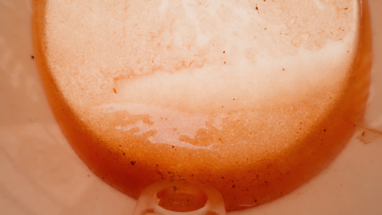 Bicchiere di carta caduto con bastoncino e avanzi di tè dolce