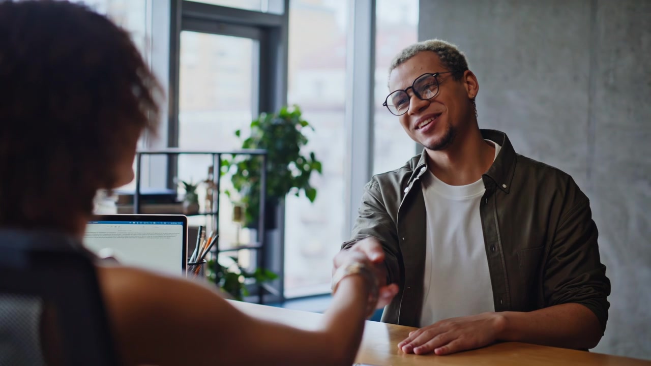 Man woman meeting office desk handshake. Young people friendly business talk