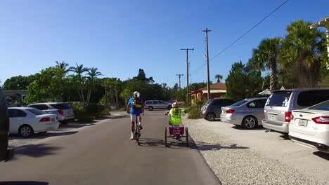 two people riding bicycles down a street