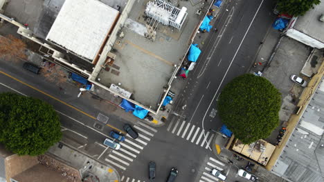 Top-down-drone-shot-rotating-over-streets-of-Skid-Row,-Los-Angeles,-USA