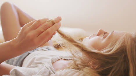 Woman-playing-with-her-hair-while-relaxing-on-a-bean-bag-indoors