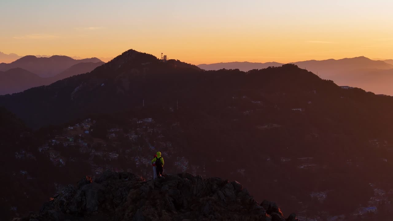 Ripresa aerea con drone che cattura l'alba dorata sulle catene montuose nebbiose di Nainital