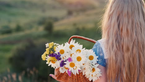 Ein-Kind-Hält-Einen-Blumenkorb-Steht-In-Den-Grünen-Hügeln