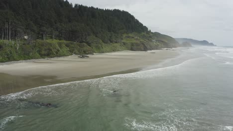 Slow-tracking-drone-shot-of-blue-green-Oregon-coast-ocean-waves